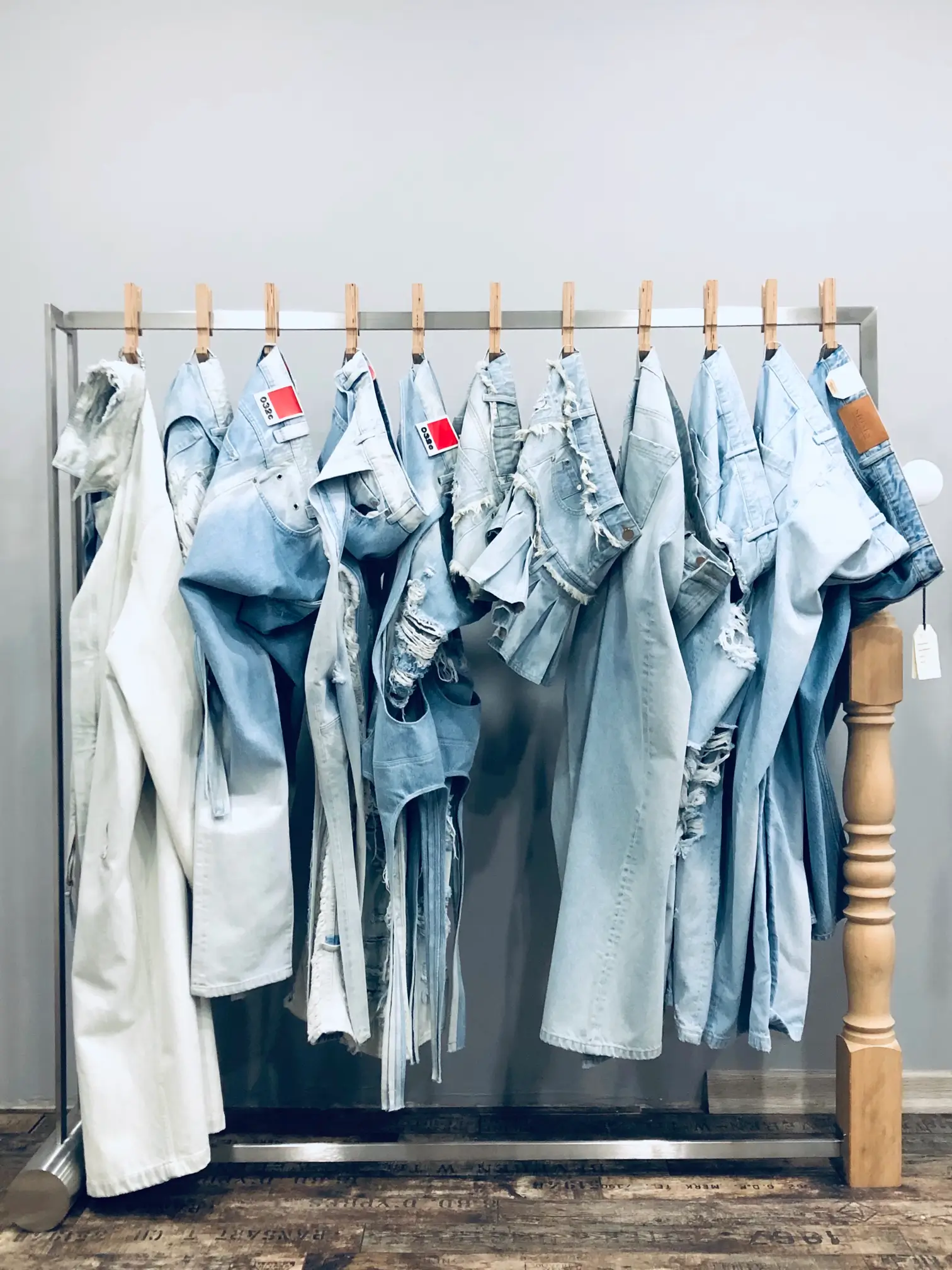 Light-wash denim garments and construction details displayed in the HASGUEL showroom