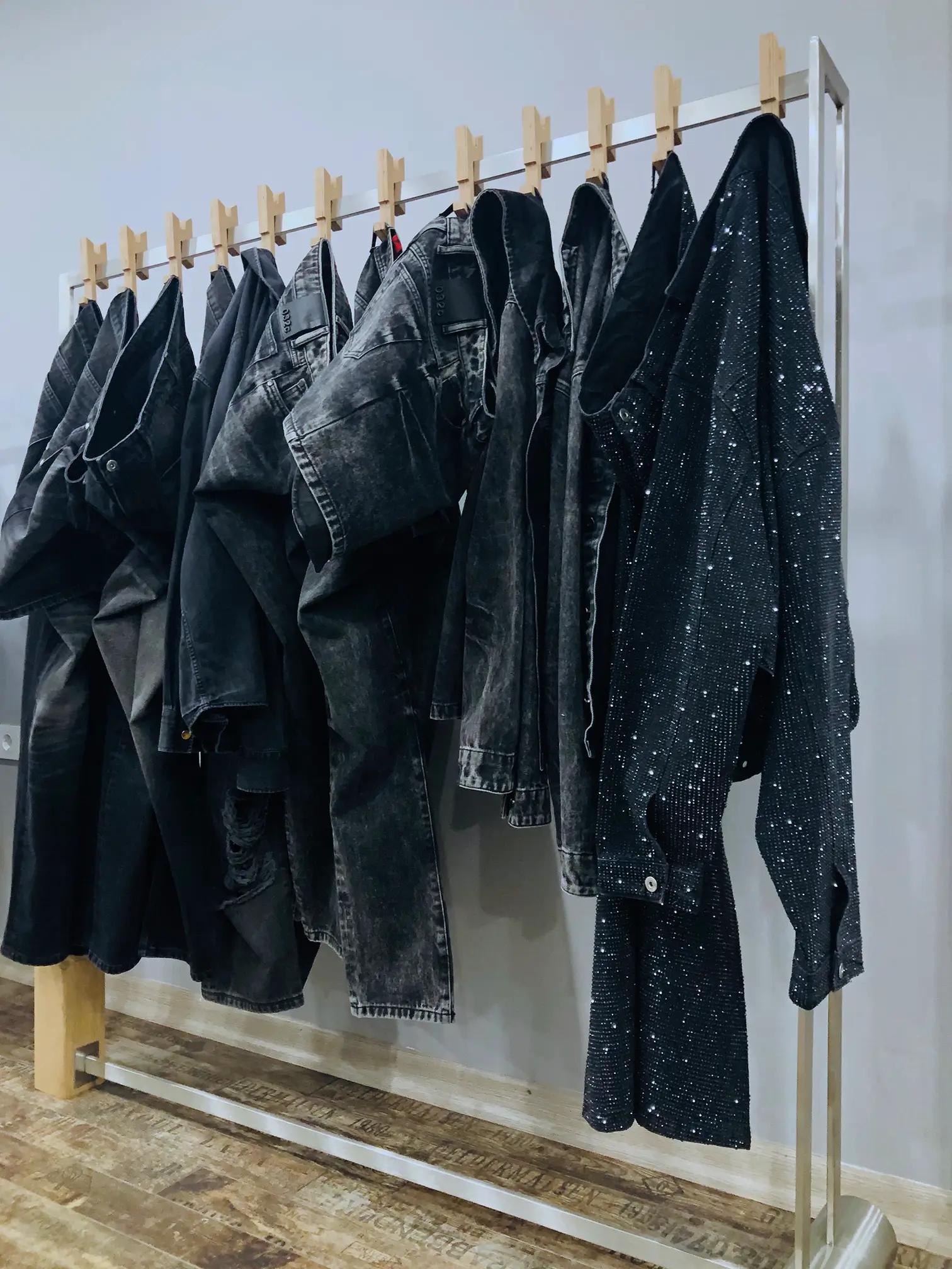 Dark garments displayed on a rail in the HASGUEL showroom